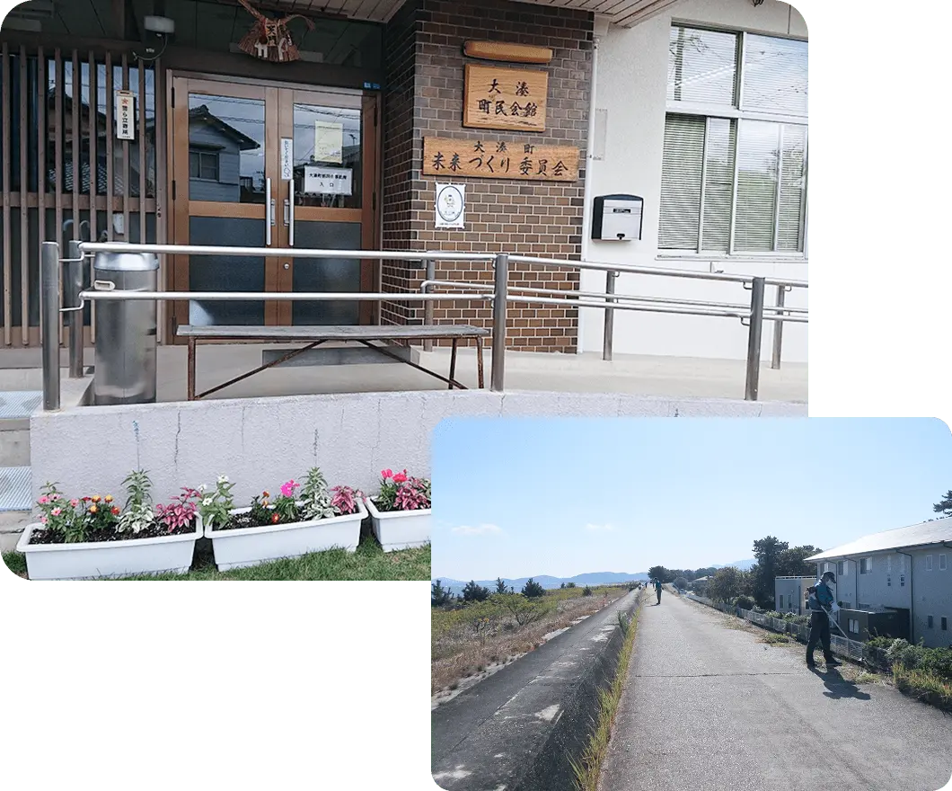 大湊町民会館の入口と未来づくり委員会の看板が掲げられた建物。手前には色とりどりの花が植えられたプランターと、奥には海沿いの道路を歩く人々の様子